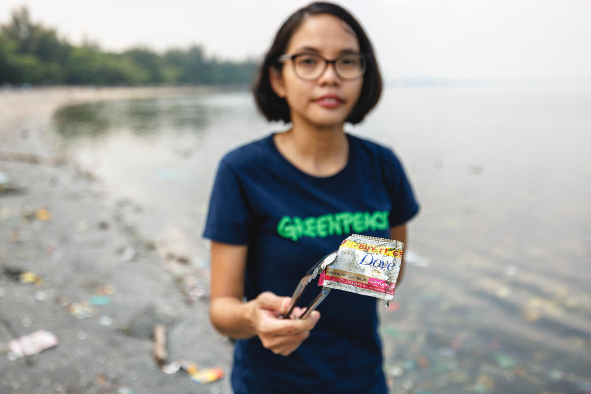 綠色和平菲律賓零廢專案主任Marian Ledesma，在調查現場夾起多芬的塑膠小包裝。