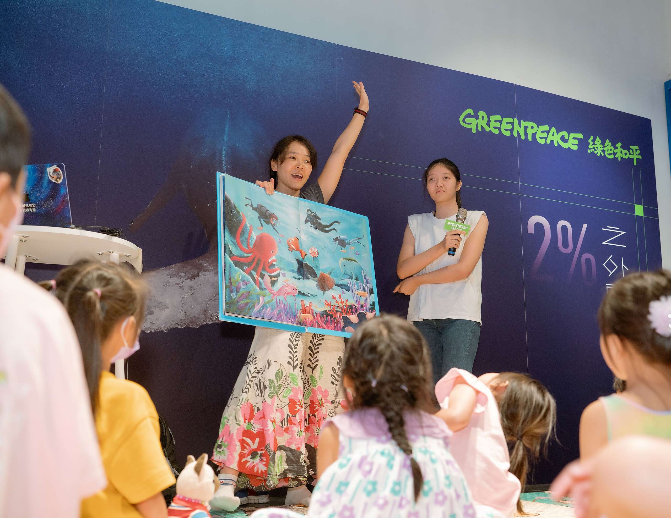 綠色和平行動者鈴鐺（左）分享作者書妍（右）所繪製的《海底音樂會》繪本，分享海洋如何透過眾人的努力，將一片髒亂的海洋恢復成色彩繽紛、生機蓬勃的環境。