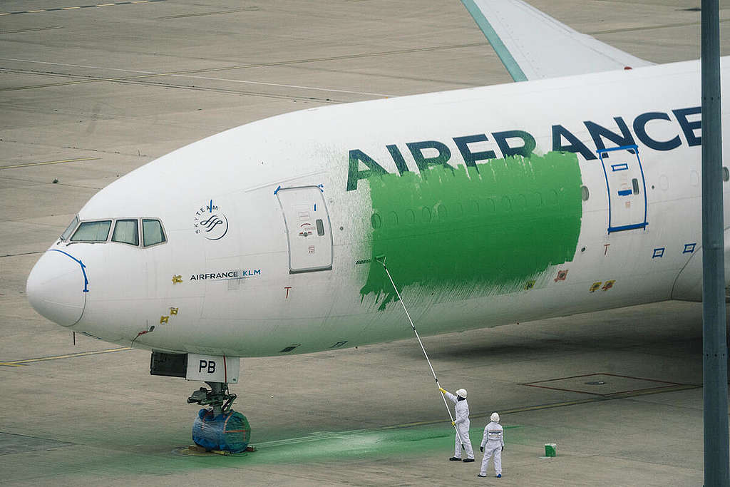Activists Paint a Plane Green in Action against Greenwashing in Paris Airport.