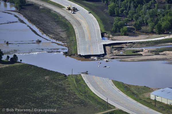 Waters recede around a washed out bridge on Colorado Highway