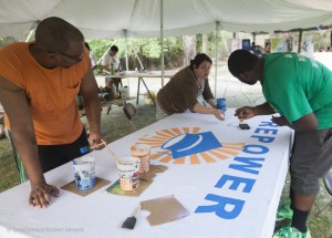 Volunteer paint a Repower Our Schools Banner
