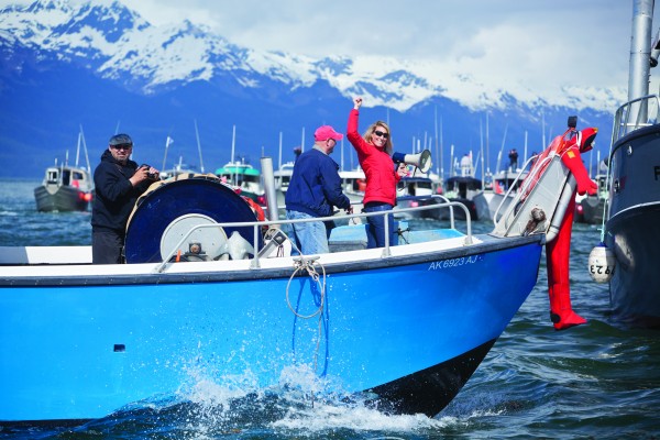 Protest organizer Emily Stolarcyk of the Eyak Preservation Council celebrates the good turnout in her efforts to object to the Navy's plans to conduct war games in the Gulf of Alaska. Driving his fishing boat is James Mykland on the Exodus and Lloyd Montgomery (left).