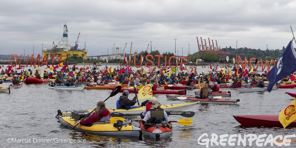 Activists participate in the sHell No Flotilla part of the Paddle In Seattle protest.  Nearly a thousand people from country gathered May 16, 2015 in Seattle's Elliott Bay for a family-friendly festival and on-land rally to protest against Shell’s Arctic drilling plans.  Photo by Greenpeace