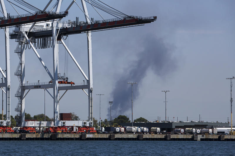 Smoke rises from an area believed to be in the vicinity of oil refineries during a tour of the fossil fuel infrastructure in the ports of Long Beach and Los Angeles to demonstrate the health and environmental justice impacts on local communities.