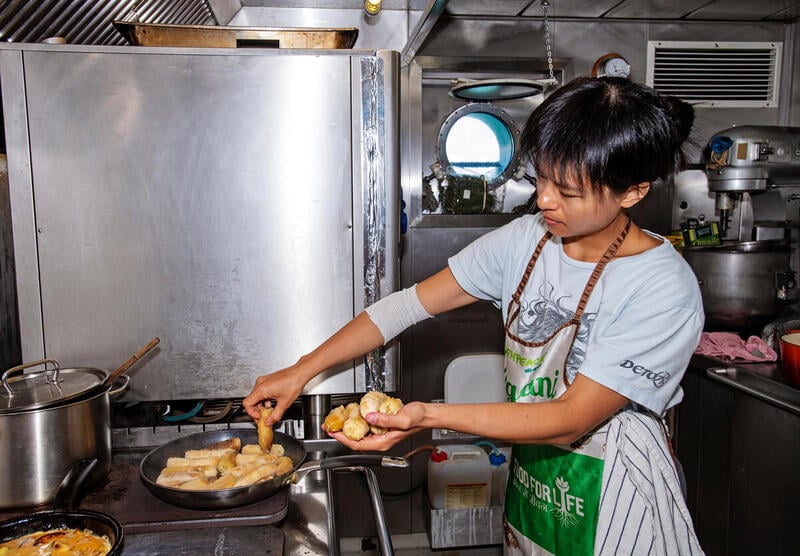 I’m assisting our Chef Laurence by frying bananas in the galley on board the Rainbow Warrior in the Pacific. © Marten van Dijl / Greenpeace
