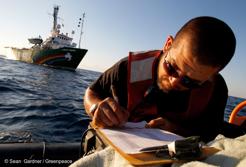 PHOTO: DOER Supervisor Rudy Schlepp writes in the dive log of the Dual Deep Worker submarine on an inflatable boat near the Greenpeace ship MY Arctic Sunrise in the Gulf of Mexico. A team of independent scientists joined the crew of the Arctic Sunrise to conduct a series of scientific research programs that will further the understanding of the impacts of both oil and chemical dispersant on the Gulf ecosystem in the aftermath of the British Petroleum oil spill.